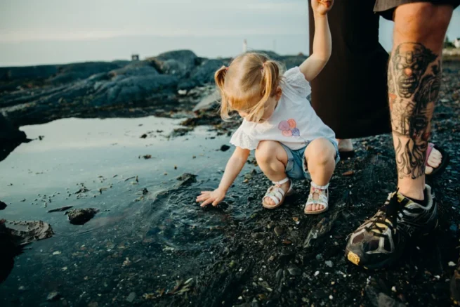 Petite fille tenant la main de sa mère, photographie documentaire en couleur et lumière naturelle à Rimouski