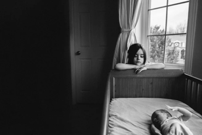 Petite fille contemplant son petit frère, portrait noir et blanc haute résolution capturé dans la région de Rimouski