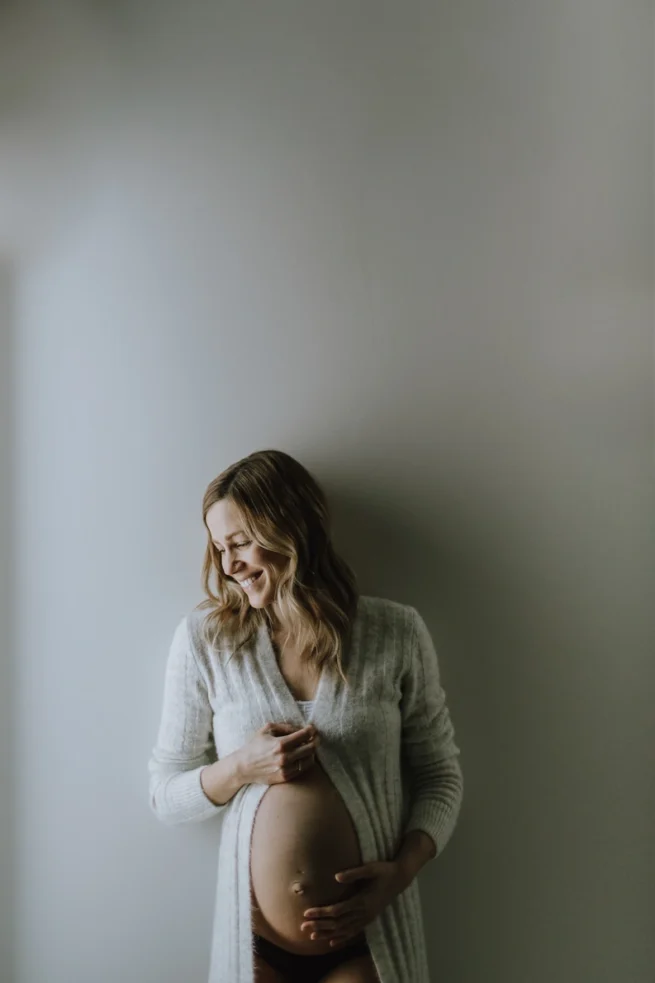 Femme enceinte souriante en lumière naturelle, portrait intérieur haute résolution à Rimouski
