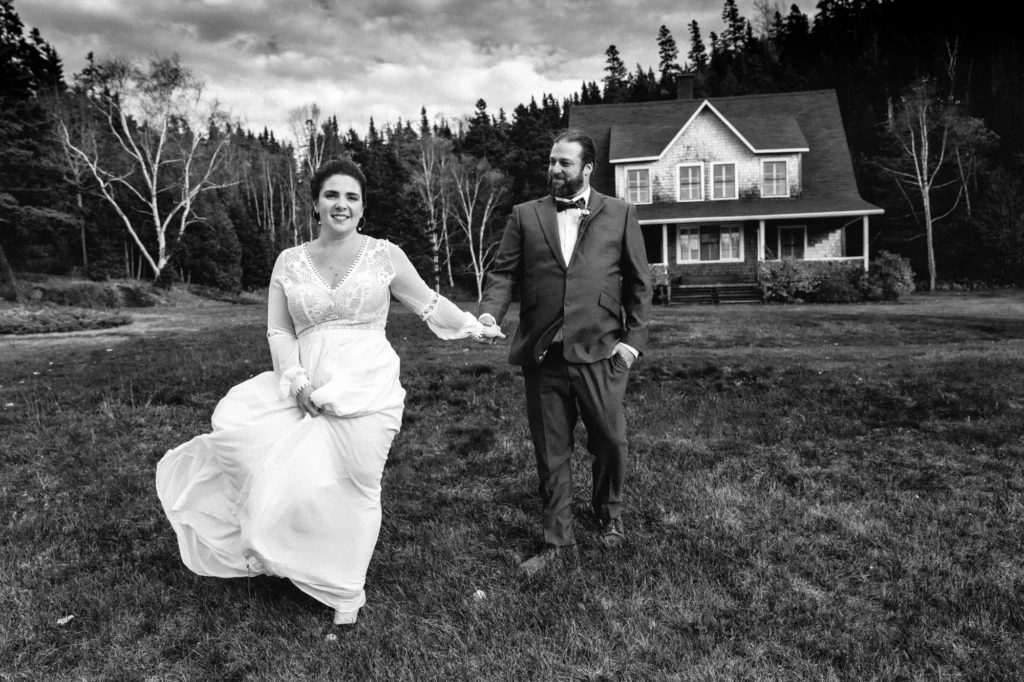 Sortie de cérémonie : mariés marchant dans un pré, esthétique documentaire.