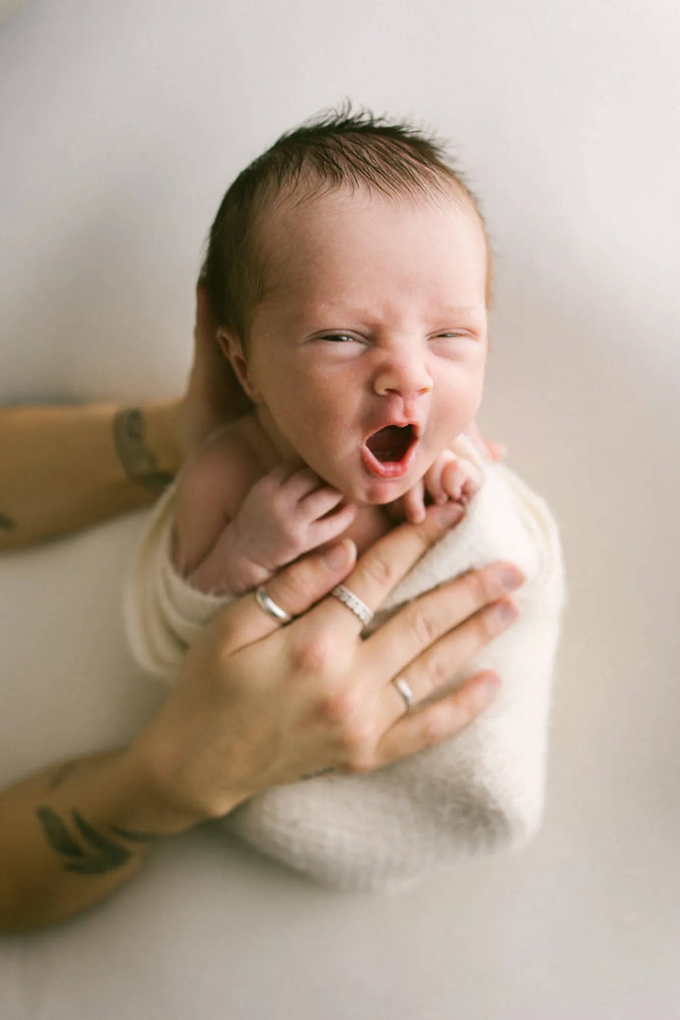 Nouveau-né qui sourit dans les mains de son parent prise par 5Mphotographie - photograhe de Rimouski