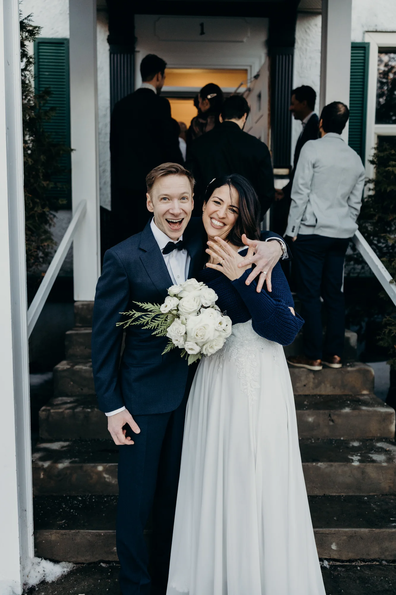 Mariés posant sur l'escalier rustique d'une résidence.