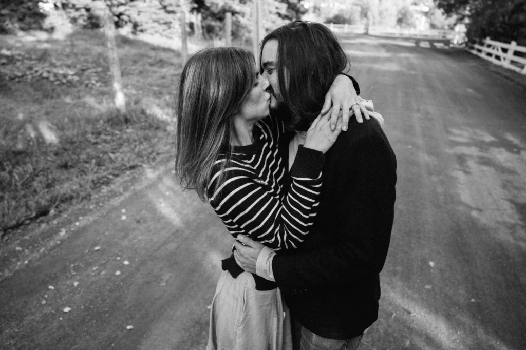 Couple marchant sur un sentier forestier, photographie noir et blanc contrastée.