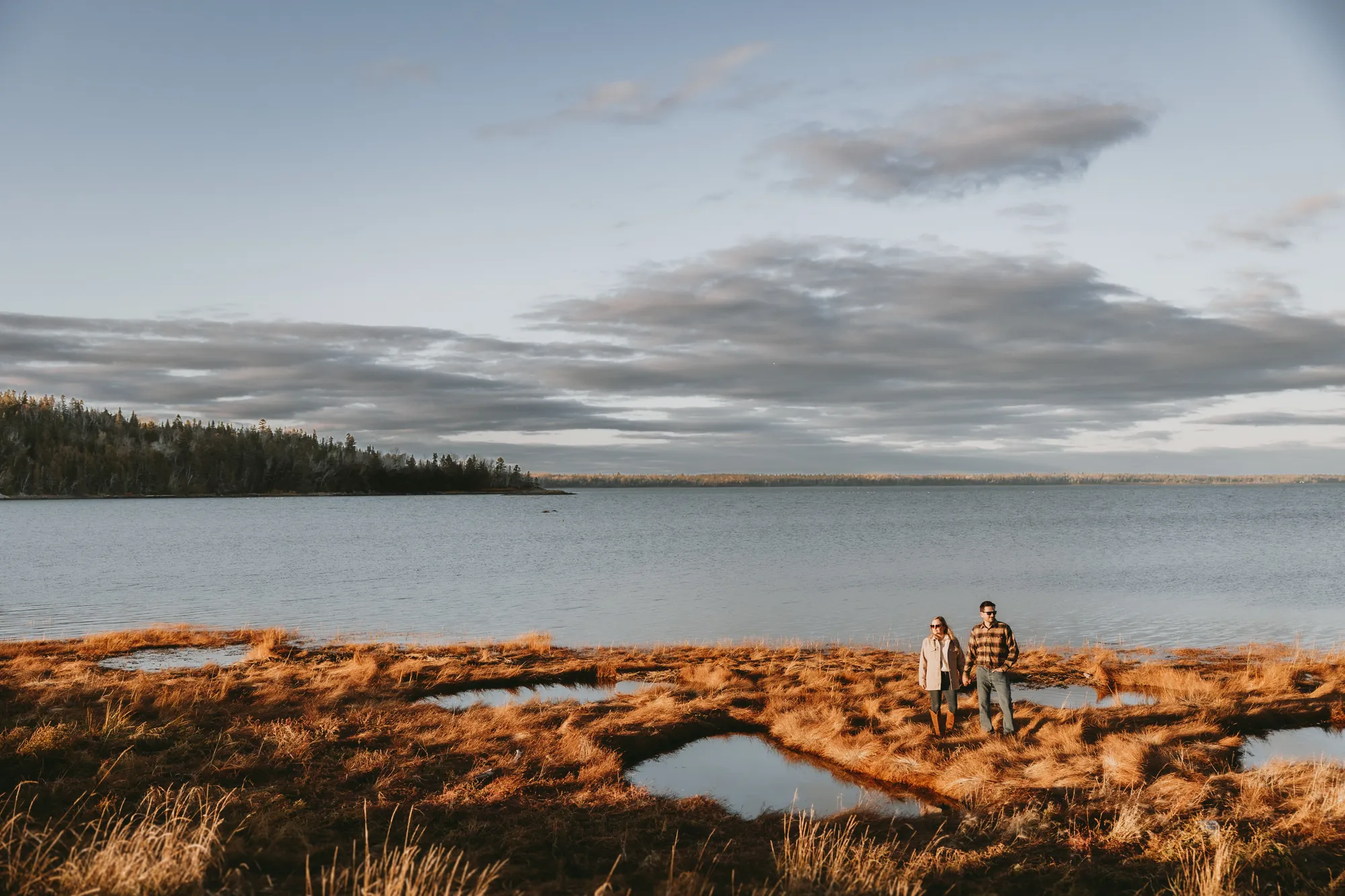 Vue panoramique de la rive et de la végétation rouge en automne et ret couple qui regarde de côté