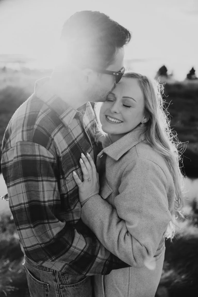 Moment secret entre deux amoureux sous les sapins en noir et blanc.