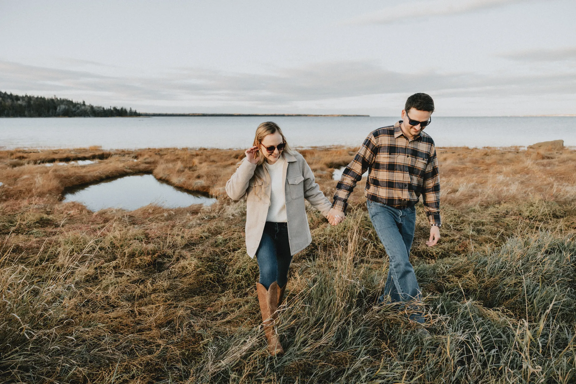 Couple s'avançant vers l'objectif avec de grands sourires naturels.