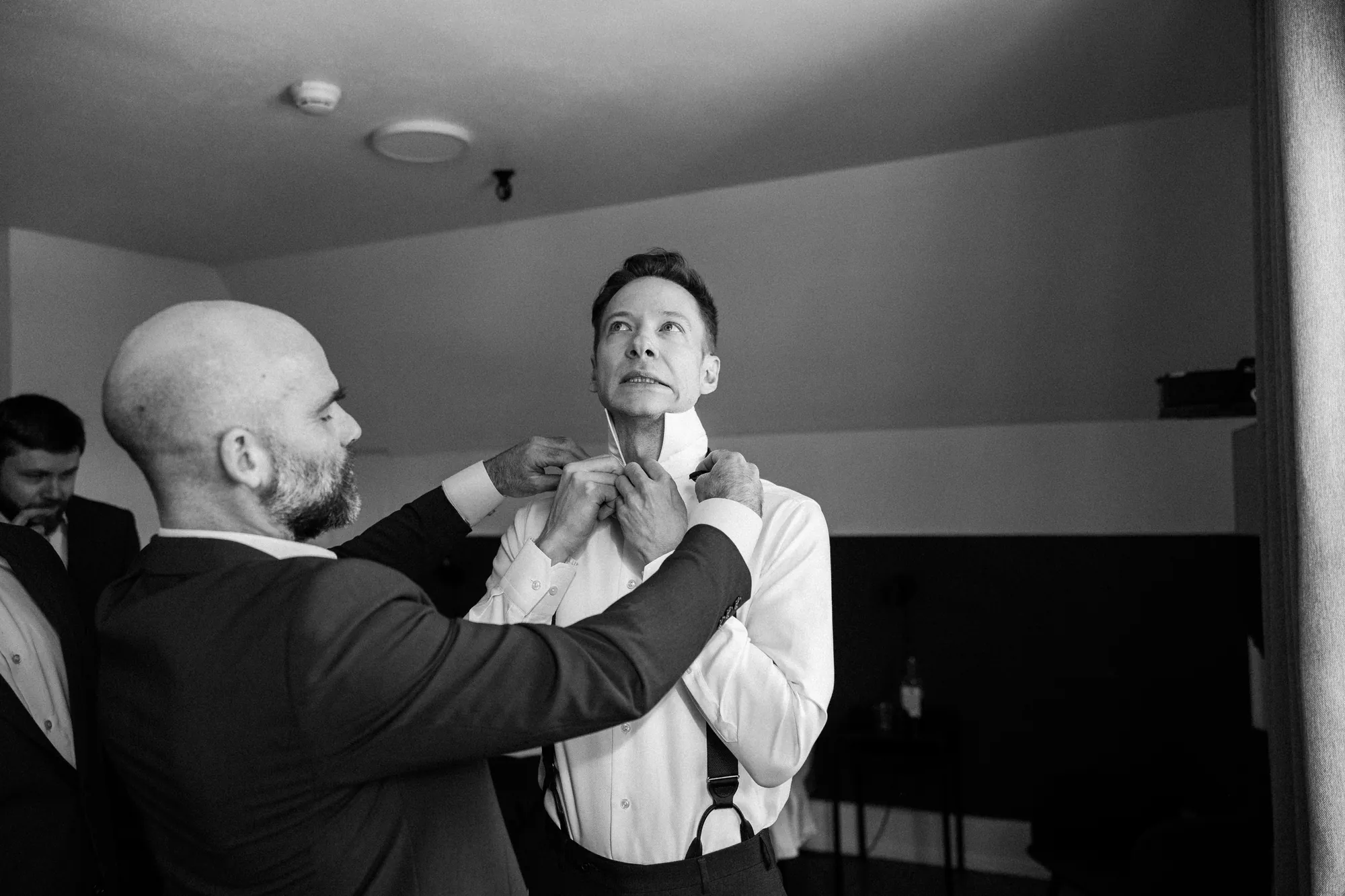 Ambiance des préparatifs de mariage vue à travers l'entrebâillement d'une porte.