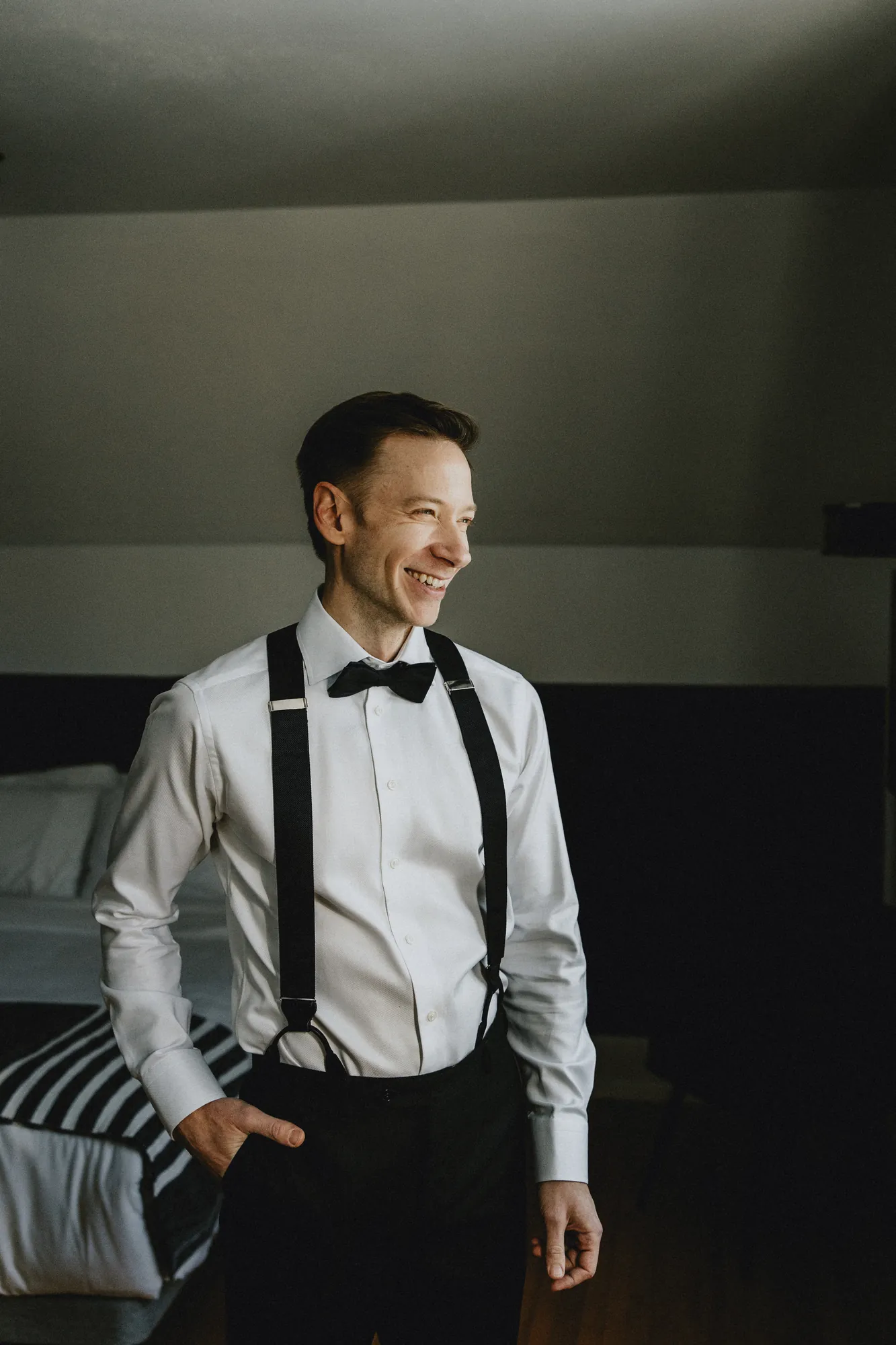 Marié en brettelle qui pose en souriant.