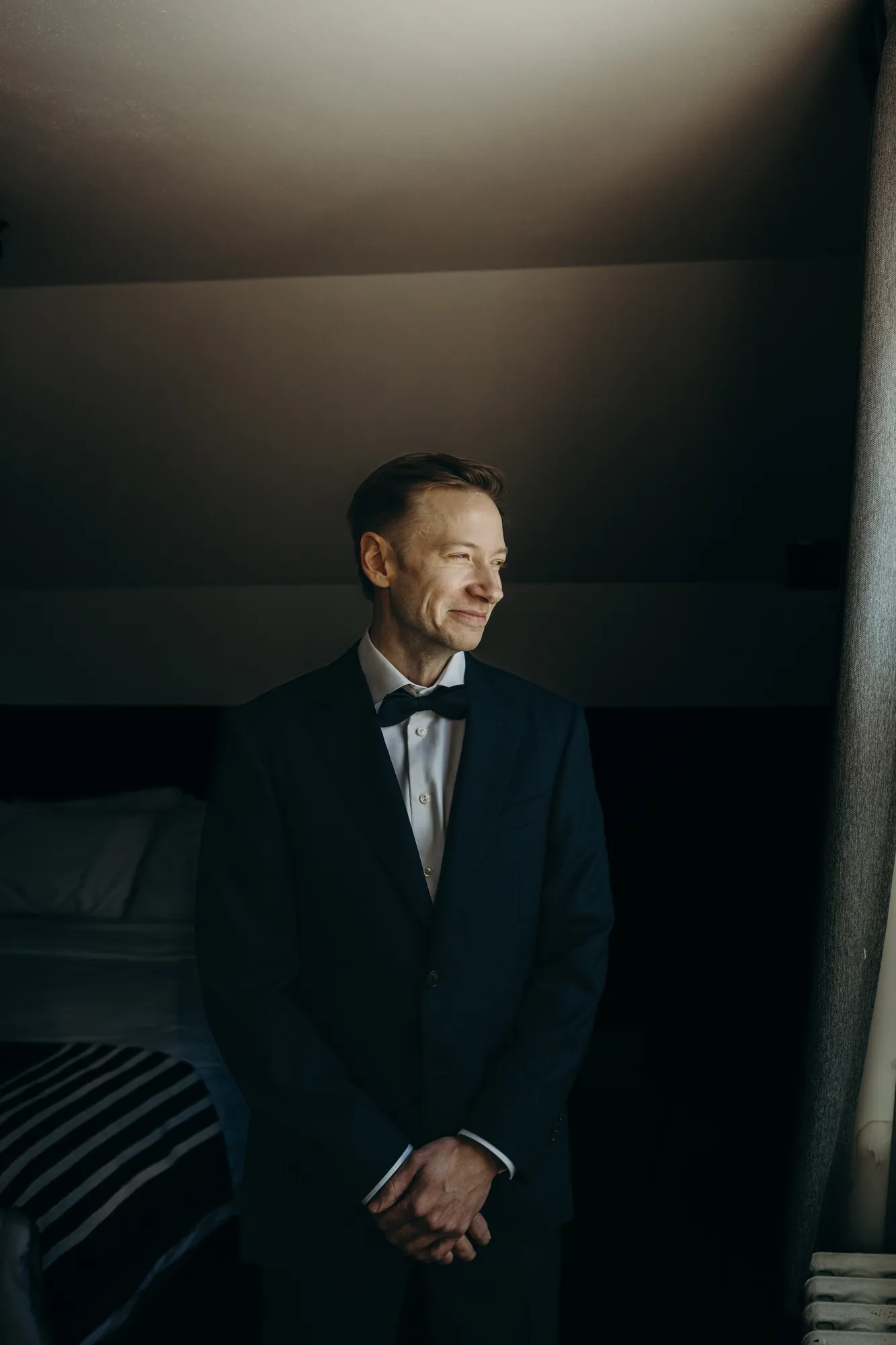 Marié avec son costume qui se tient les mains.