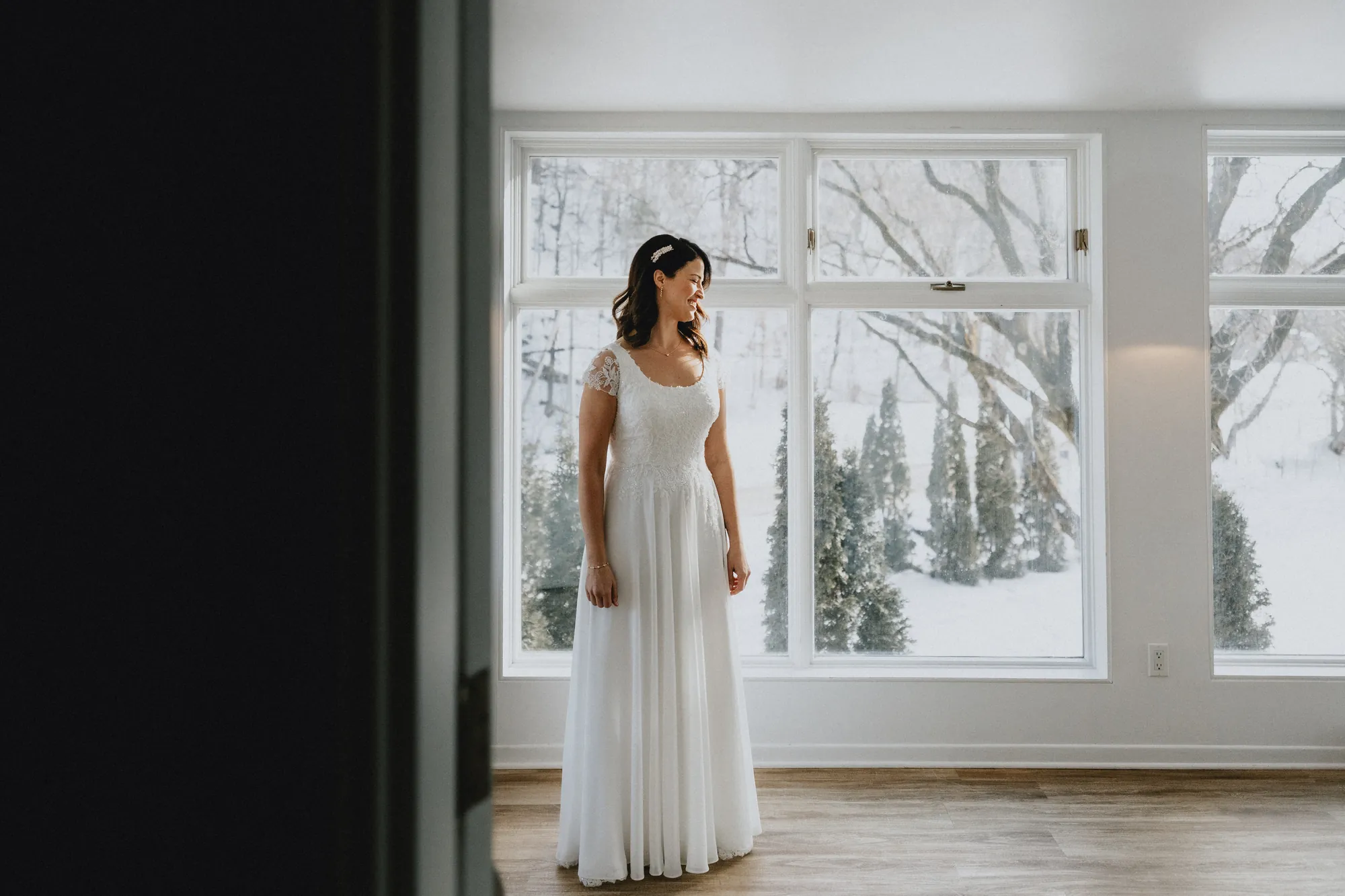Portrait de la mariée Lindsay pensive durant sa séance près d'une grande fenêtre.