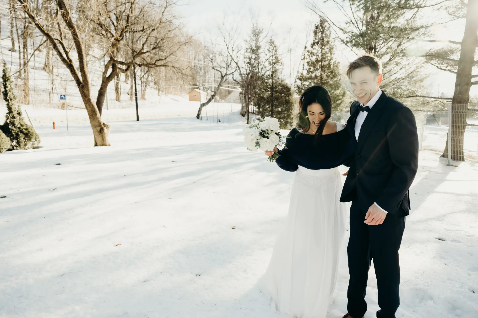 Couple de mariés marchant ensemble dans un champ de neige immaculé à Beaupré.