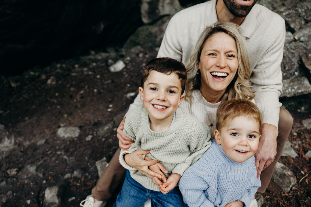 Famille de 2 enfants et une maman qui tient ses enfants dans ses bras prise par une photographe de Rimouski