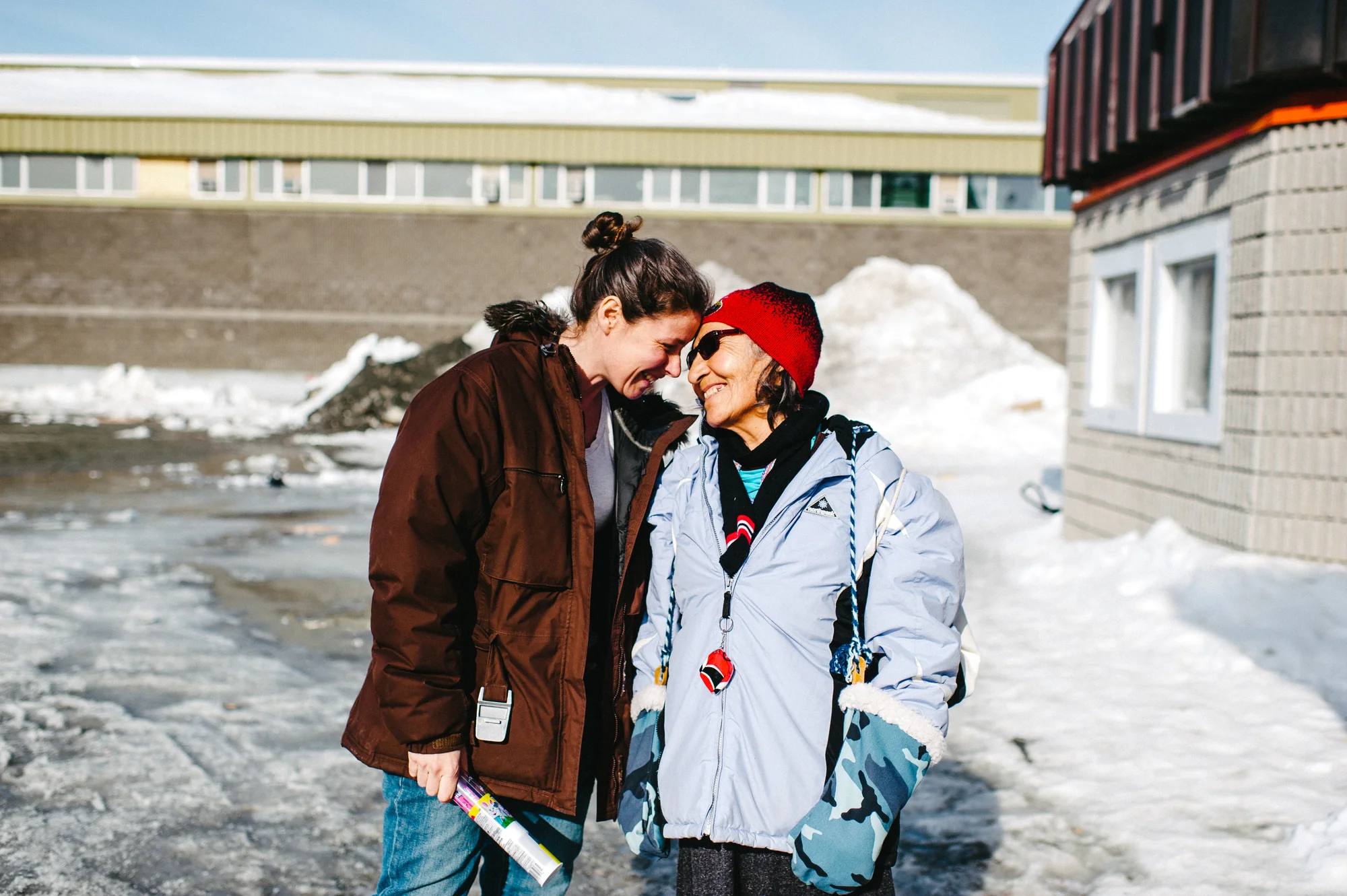 Catherine Hudon (5Mphotographie) en moment de partage avec une femme crie à Chisasibi, illustrant la résilience et l'approche humaine de la photographe à Rimouski.