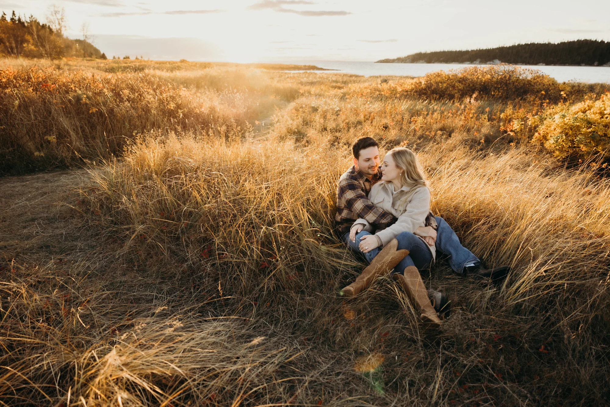 Amoureux assis dans un champ de blé doré au coucher du soleil.