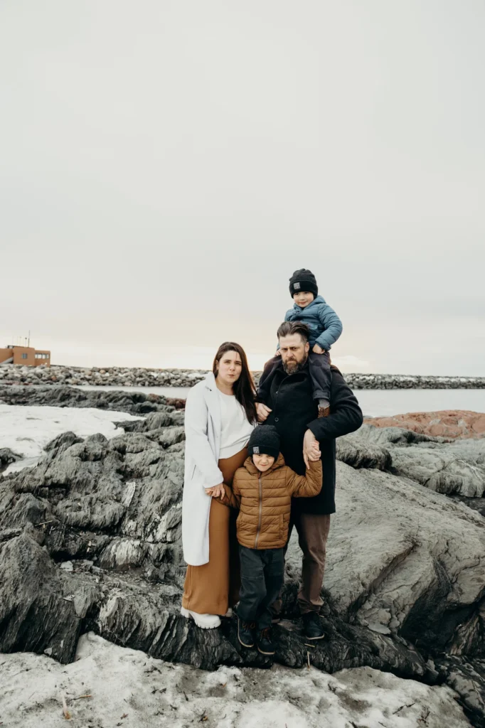 Famille au complet (Alex, Christian, Joseph et Jean) sur les rochers enneigés de Rimouski.