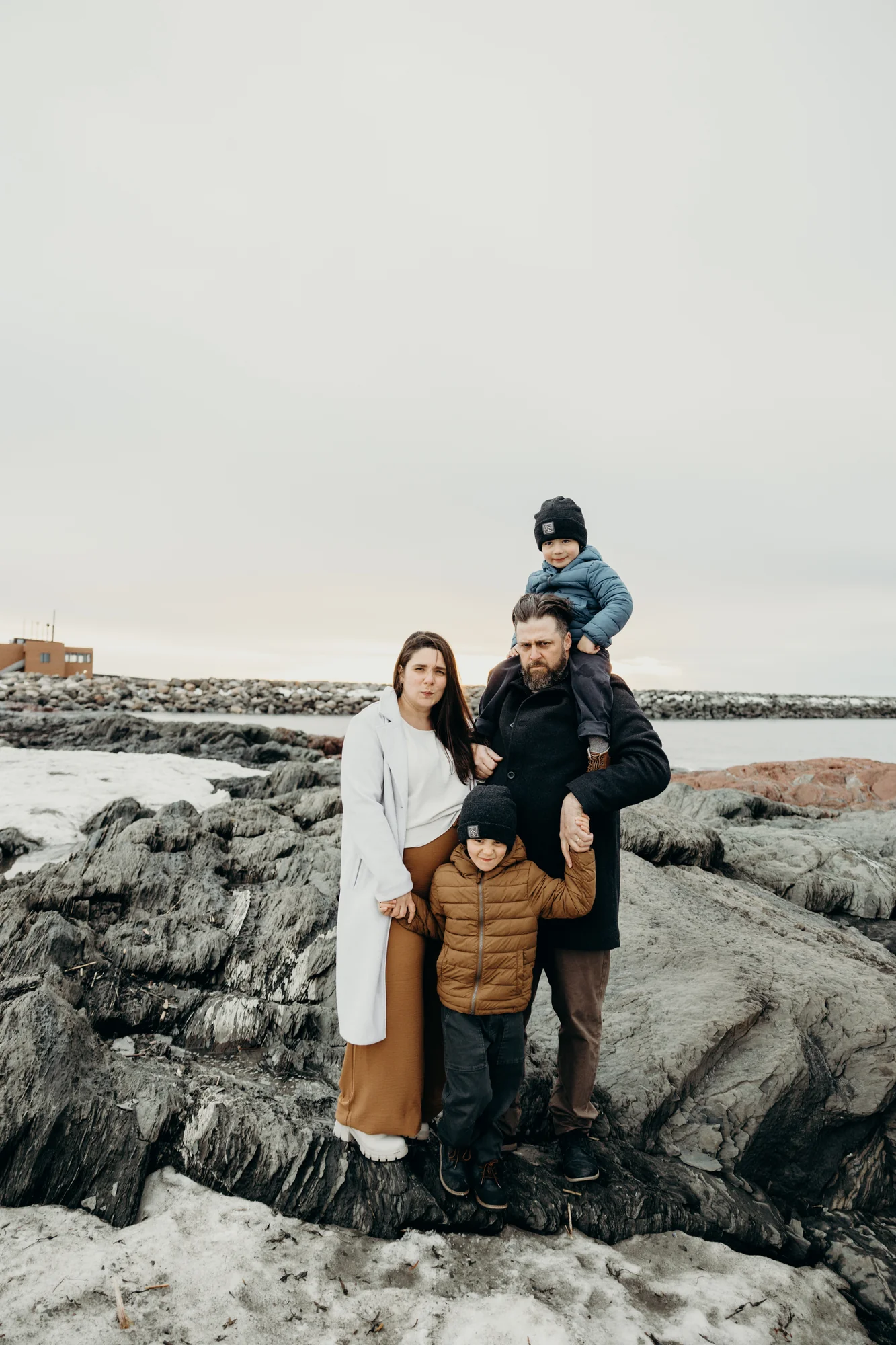 Famille au complet (Alex, Christian, Joseph et Jean) sur les rochers enneigés de Rimouski.