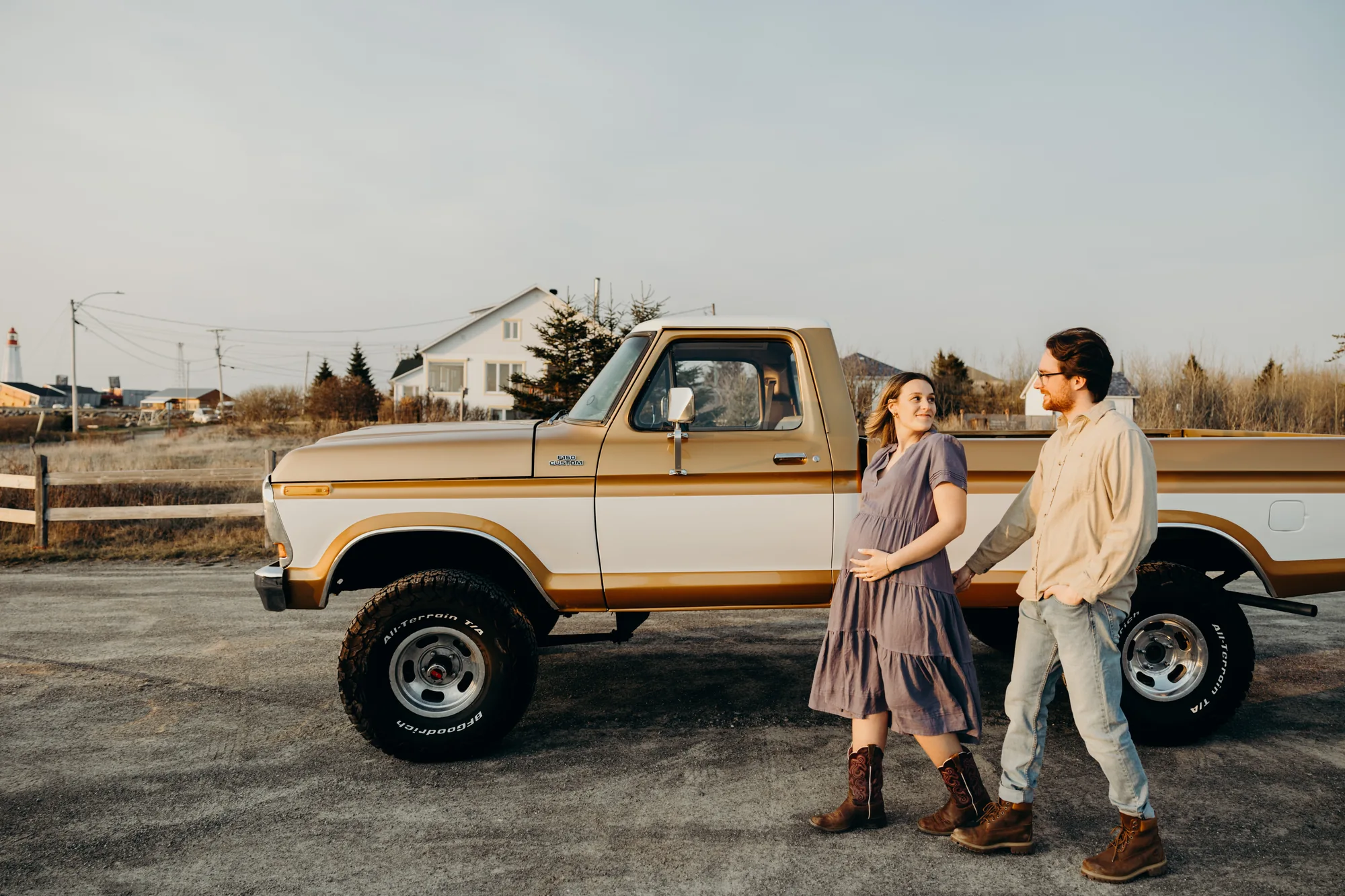 Couple marchant main dans la main vers leur pick-up au coucher du soleil.