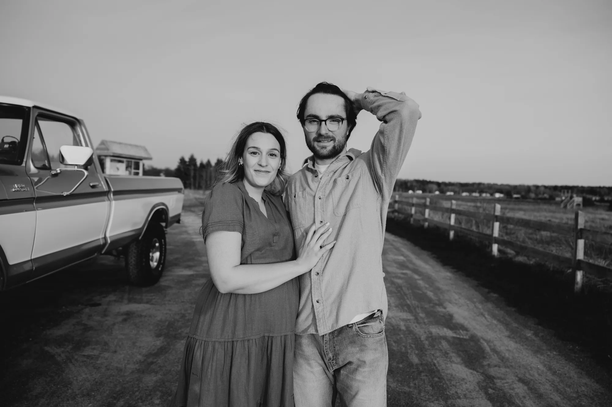 Photo authentique de 5Mphotographie en noir et blanc d'une femme enceinte et son conjoint qui se touche les cheveux.