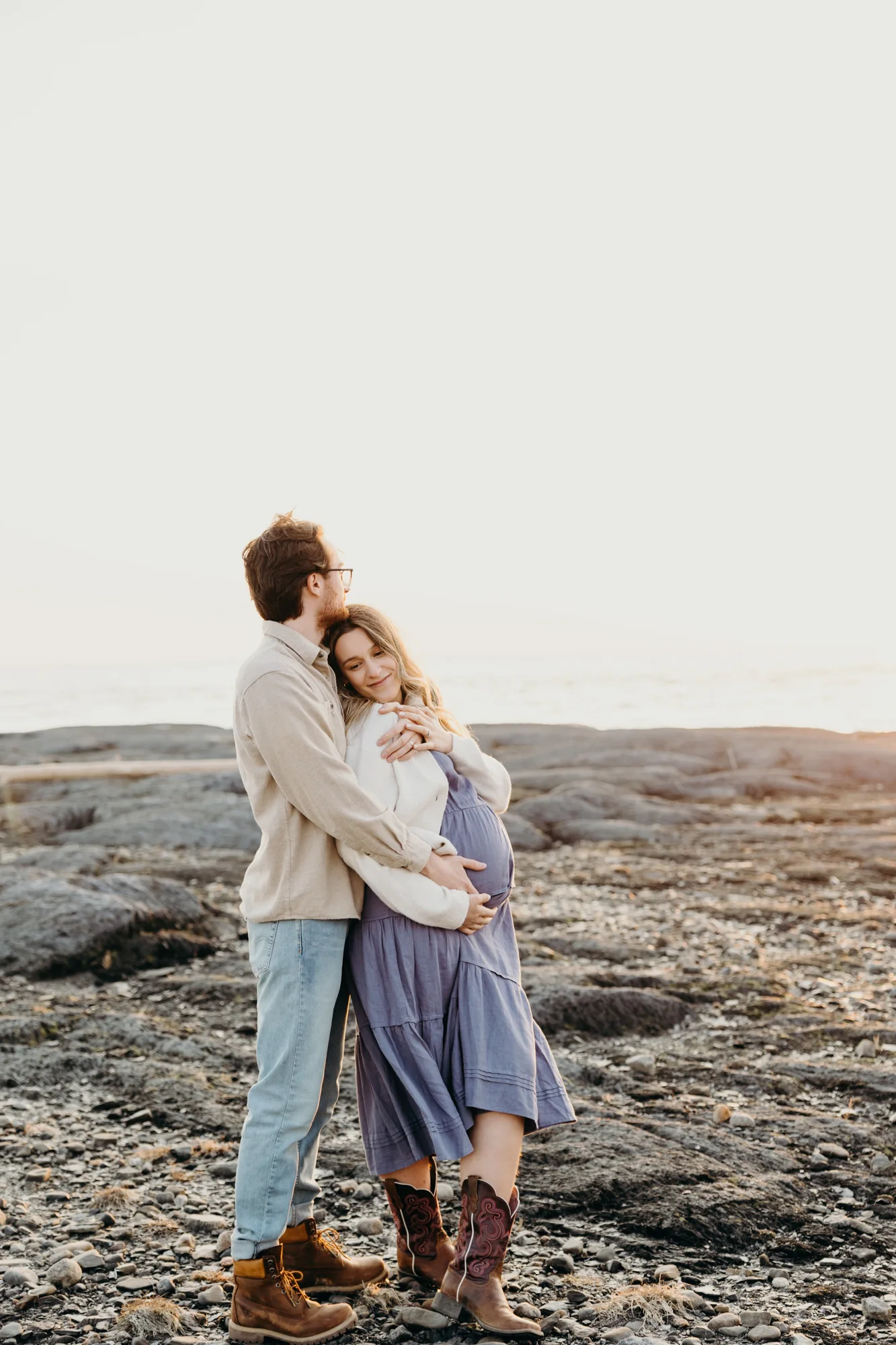 Portrait intime d'un couple s'enlaçant, séance grossesse au Bas-Saint-Laurent avec 5Mphotographie.
